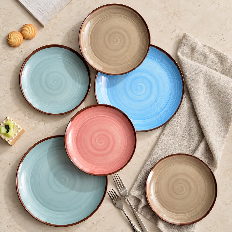Round plates in blue, pink and sand tones with a swirl pattern, seen from above